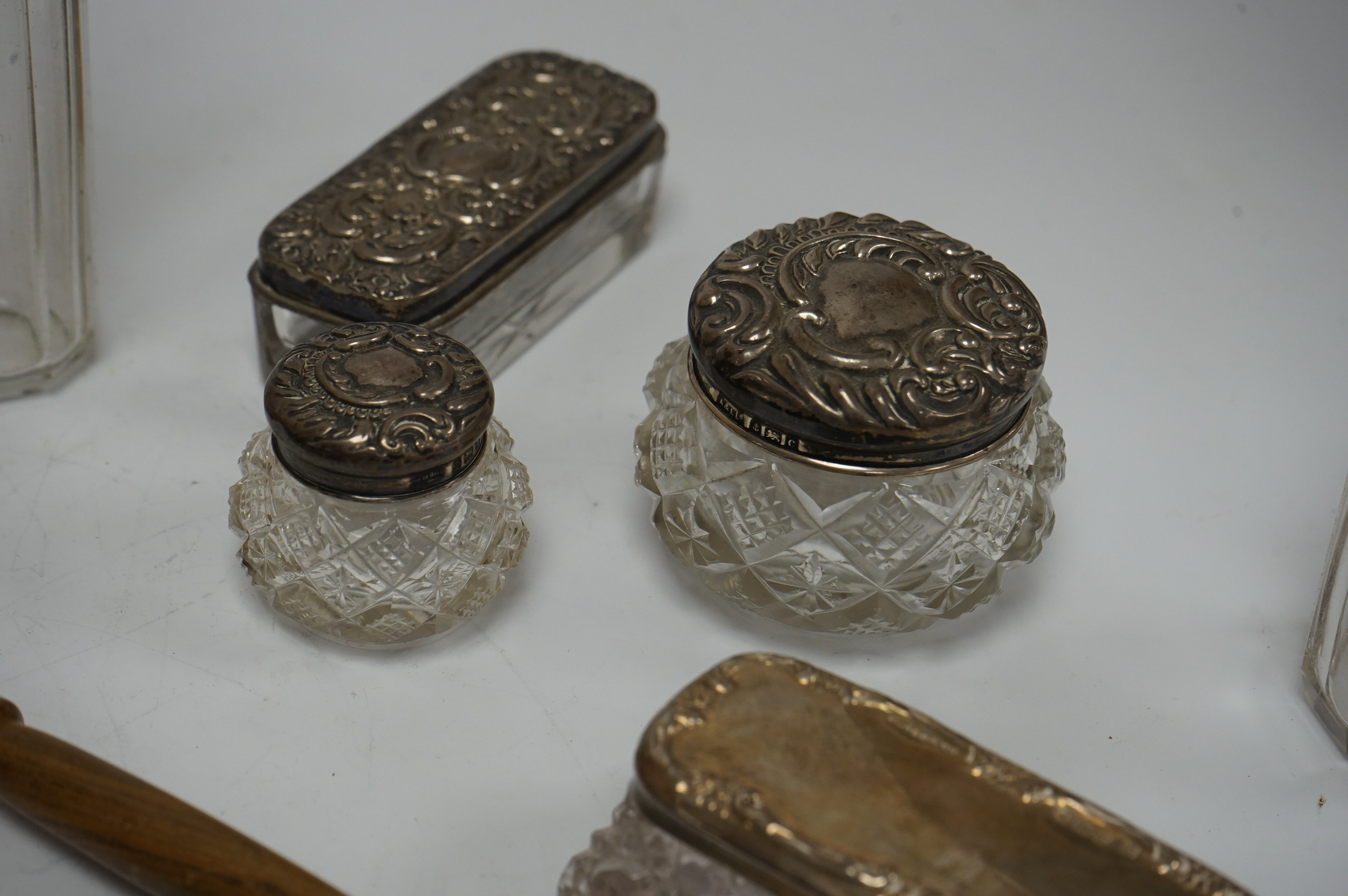 A cased set of five(ex 6) Edwardian repousse silver buttons, import marks for London, 1902, 33mm, a modern wooden handled silver extinguisher, six assorted Victorian and later silver mounted glass toilet jars and a cased